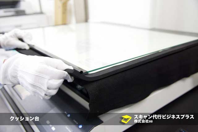 クッション台を利用して折りたたみ線を平らにしている様子